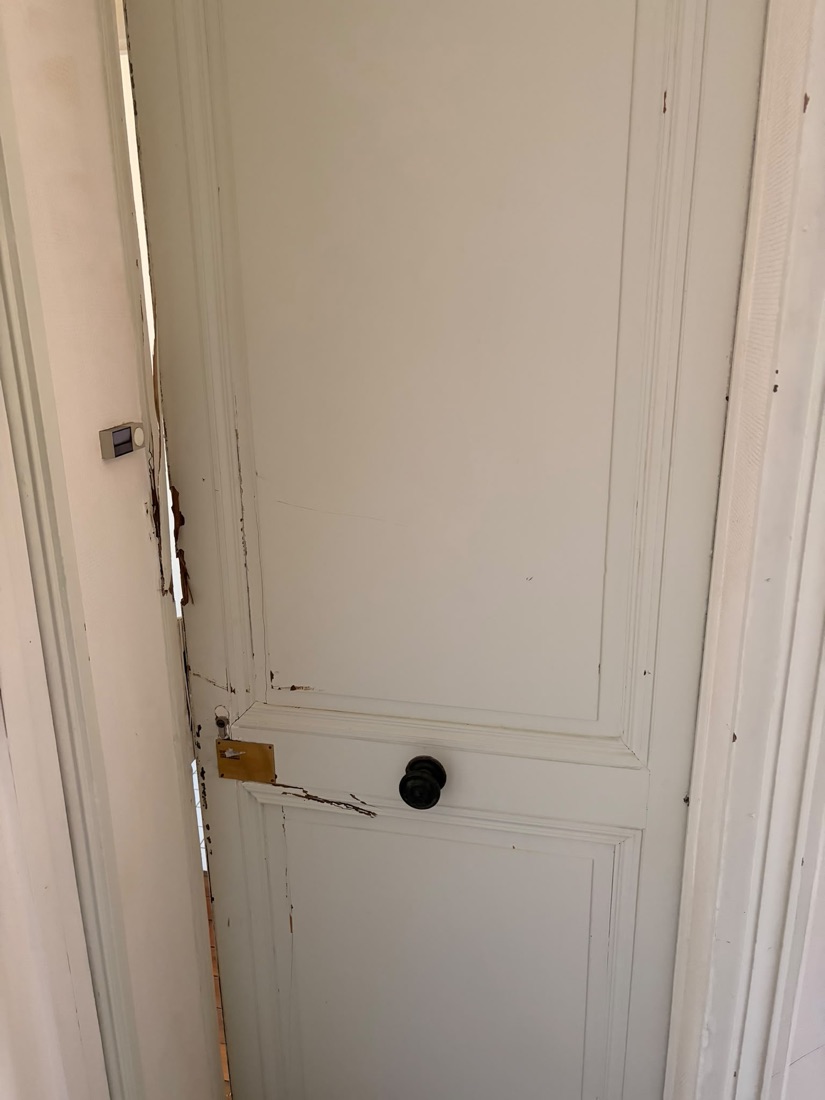 Chambranle éclaté au niveau de la gâche d'une porte à moulures après effraction